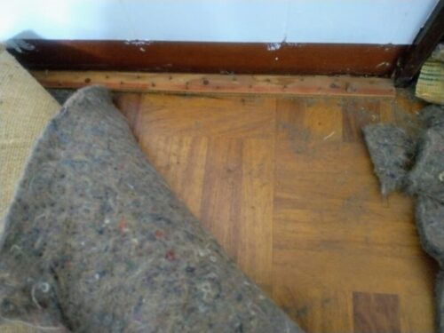 リビング床に刺さったグリッパー工法の釘