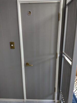 ペンキを塗って綺麗になった廊下の壁とトイレのドア